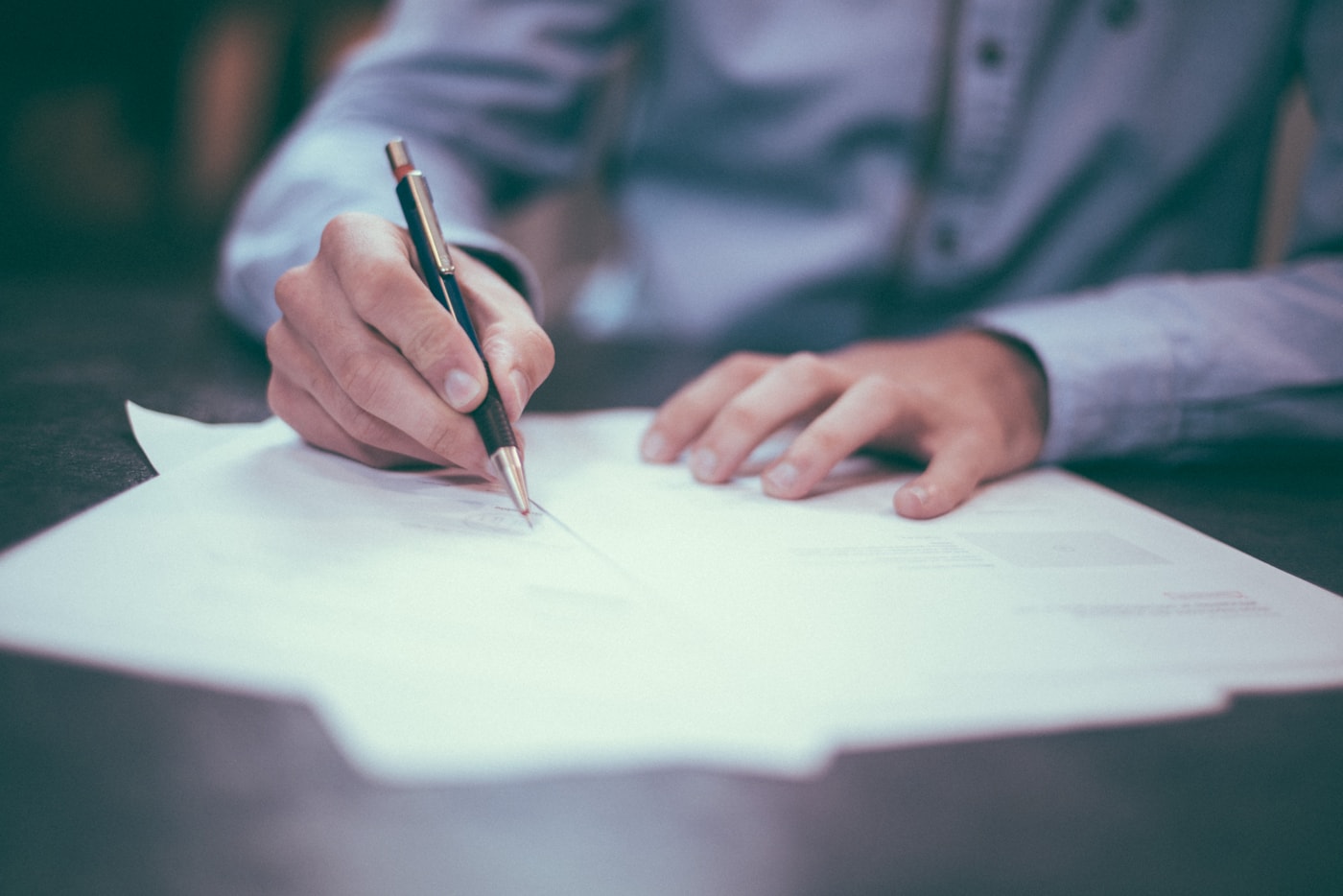 Hands reviewing printed documents at a desk, as used when checking cited court and press records